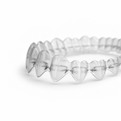 Close-up of clear Invisalign aligners on a white background, demonstrating their discreet nature.