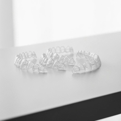 Close-up of a set of clear Invisalign aligners on a clean, modern surface