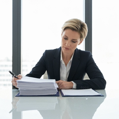 Woman reviewing financial documents at a desk, implying financial planning for Invisalign treatment.